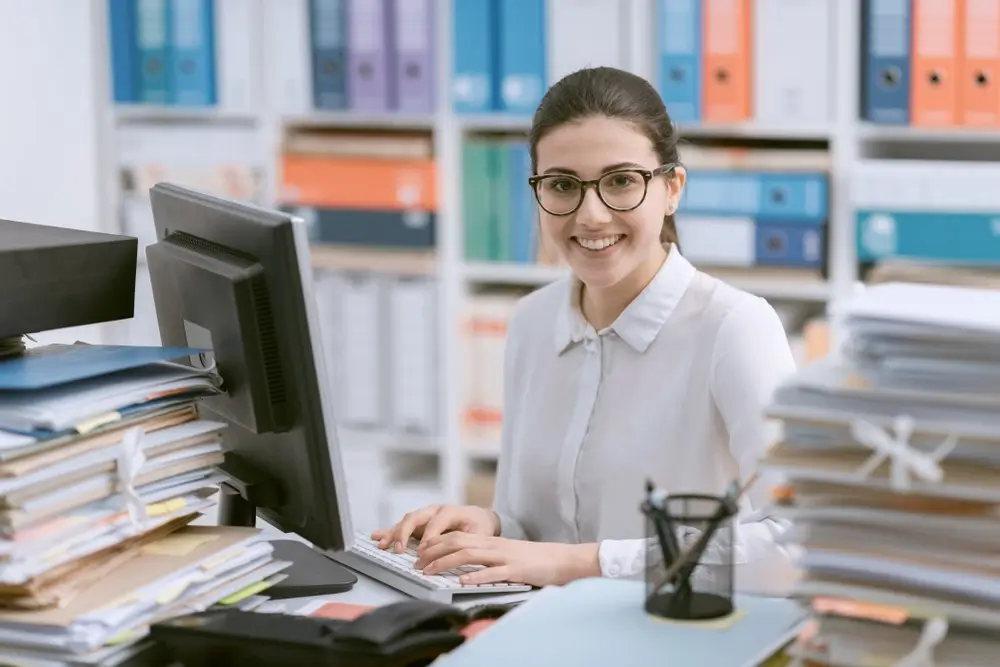 Smiling female accountant checking bookkeeping records at work