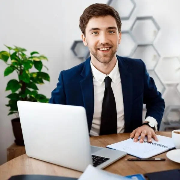 Male dressed in a navy colored suit in an office